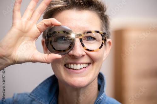 woman with glasses looking through tinted glass
