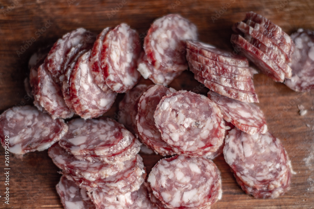 cut sausage with a knife on a wooden board cut sausage with a knife on a wooden board