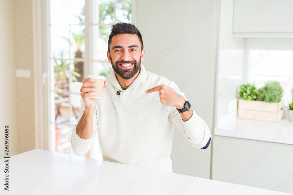 Handsome hispanic man drinking a coffee in a paper cup with surprise face pointing finger to himself Handsome hispanic man drinking a coffee in a paper cup with surprise face pointing finger to himself