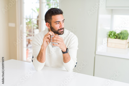 Handsome man smiling while enjoying drinking a cup of coffee in the morning