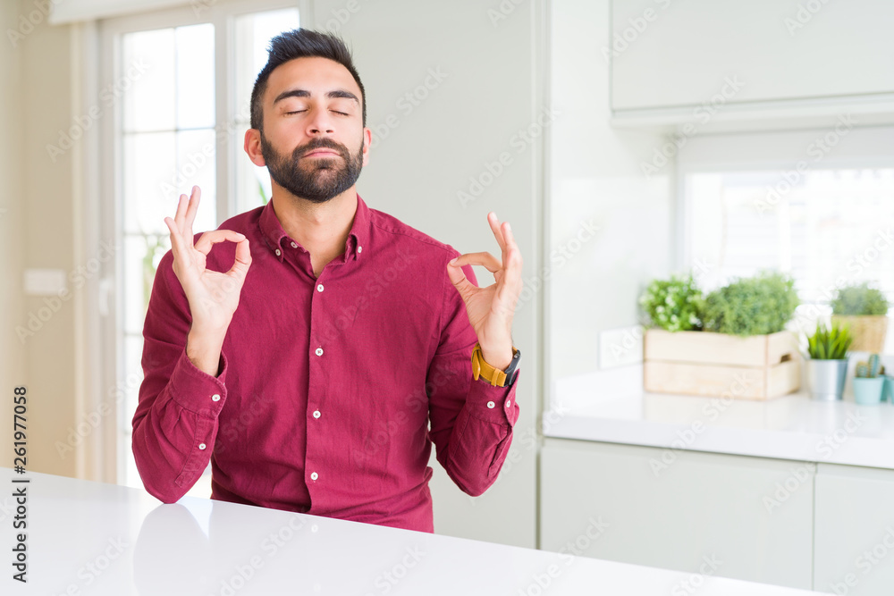 Handsome hispanic business man relax and smiling with eyes closed doing meditation gesture with fingers. Yoga concept. Handsome hispanic business man relax and smiling with eyes closed doing meditation gesture with fingers. Yoga concept.