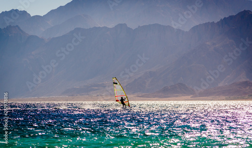 surfer ride in the sea on the background of the rocky coast in Egypt Dahab