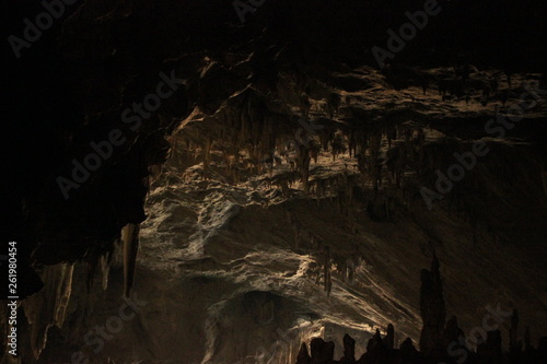 wide angle panoramic view showing the opening of a cave, Thum Lod cave, Bang Ma Pha, in Northern Thailand. Touristed cave with stalagmites and stalactites and a river running thru it. photo