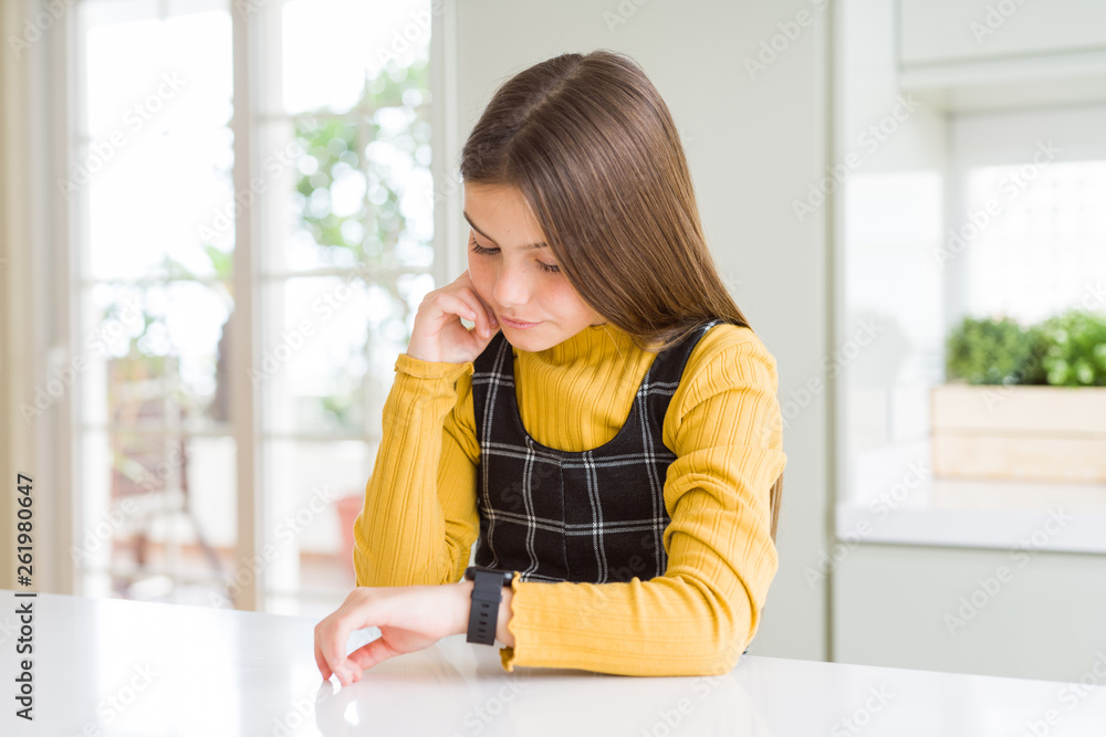 Young beautiful blonde kid girl wearing casual yellow sweater at home Checking the time on wrist watch, relaxed and confident Young beautiful blonde kid girl wearing casual yellow sweater at home Checking the time on wrist watch, relaxed and confident