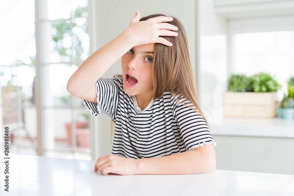 Beautiful young girl kid wearing stripes t-shirt surprised with hand on head for mistake, remember error. Forgot, bad memory concept. Beautiful young girl kid wearing stripes t-shirt surprised with hand on head for mistake, remember error. Forgot, bad memory concept.