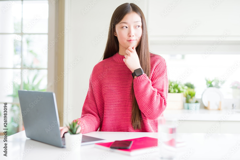 Beautiful Asian woman working using computer laptop serious face thinking about question, very confused idea