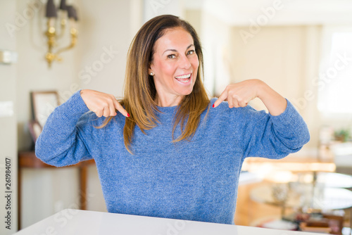 Bild auf Leinwand Beautiful middle age woman at home looking confident with smile on face, pointing oneself with fingers proud and happy