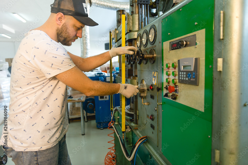 Young man working in a vinyl factory