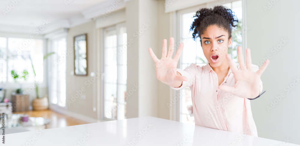 Wide angle of beautiful african american woman with afro hair doing stop gesture with hands palms, angry and frustration expression Wide angle of beautiful african american woman with afro hair doing stop gesture with hands palms, angry and frustration expression