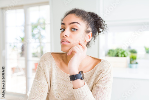 Beautiful young african american woman with blue eyes relaxing at home, with confident expression on face