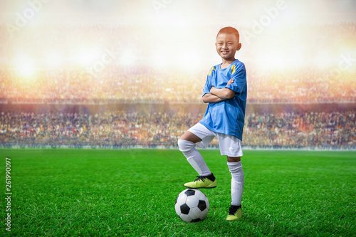 asian soccer kids player foot on the soccer ball in the stadium © pixfly