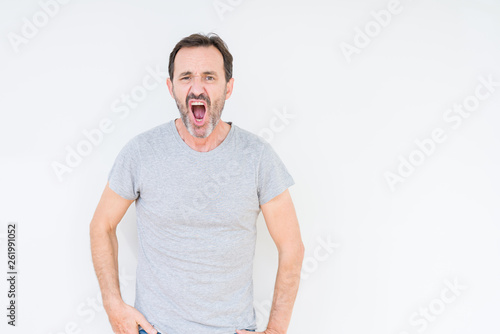 Handsome senior man over isolated background In shock face, looking skeptical and sarcastic, surprised with open mouth