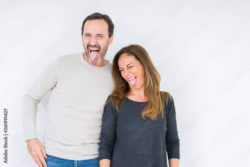 Beautiful middle age couple in love over isolated background sticking tongue out happy with funny expression. Emotion concept. Beautiful middle age couple in love over isolated background sticking tongue out happy with funny expression. Emotion concept.