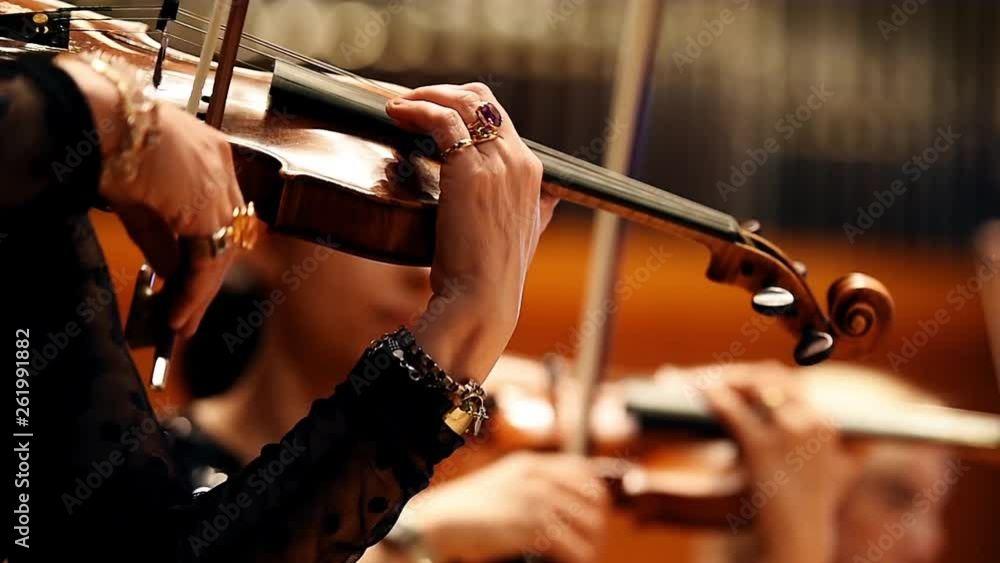 Violin players hand detail during philharmonic orchestra performance