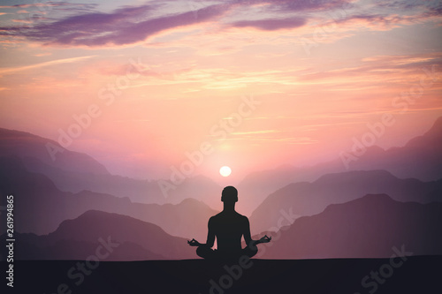 Man practices yoga and meditates on the mountain.