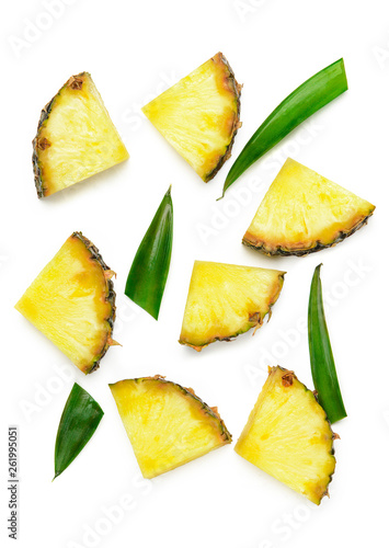 Slices of unpeeled pineapple and green pineapple leaves on a white background isolate. Juicy summer tropical dietary fruit. Top view, flat lay.