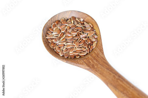 Brown flax seed in spoon on white background.