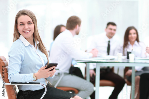 young employee with a smartphone on the background of business team