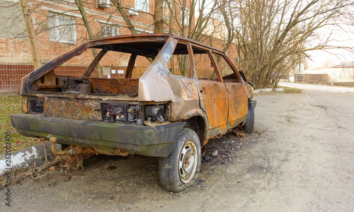 Abandoned burned passenger car near the apartment building. Russia.