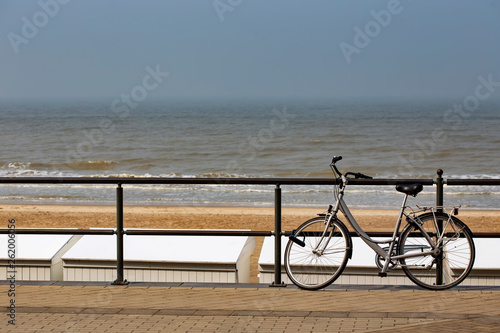 Parked bicycle on a fence near the sea in Middelkerke photo