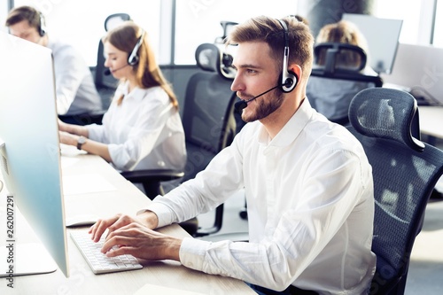 Фотография Happy young male customer support executive working in office.