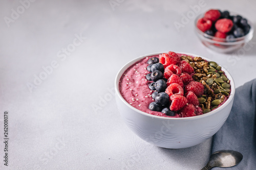 Acai bowl of smoothies with raspberries, blueberries, walnuts, pumpkin seeds and sesame