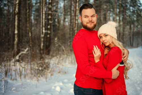 the couple in the red sweater in the winter in the forest happy hug romance © Екатерина Переславце
