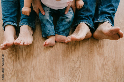 family feet on their home floor with their baby