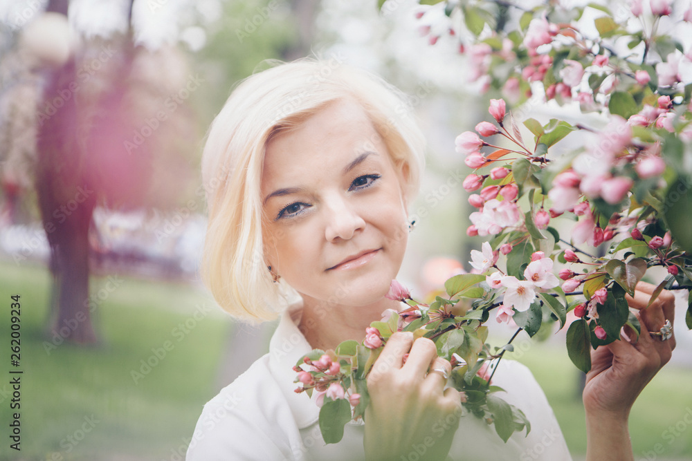 portrait of a beautiful blonde with short hair among flowers portrait of a beautiful blonde with short hair among flowers