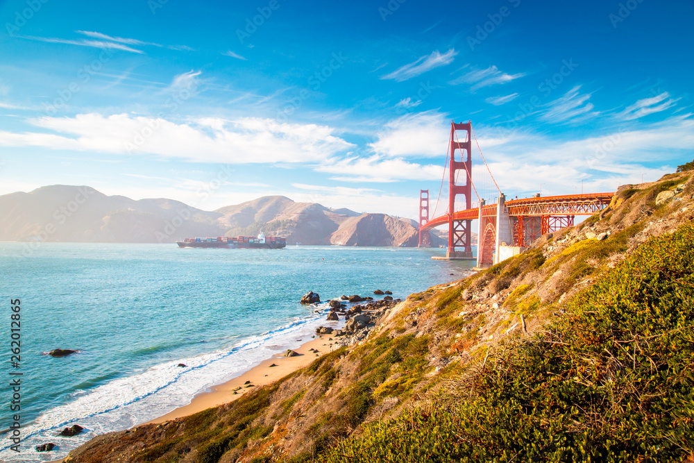 Golden Gate Bridge with cargo ship at sunset, San Francisco, California, USA