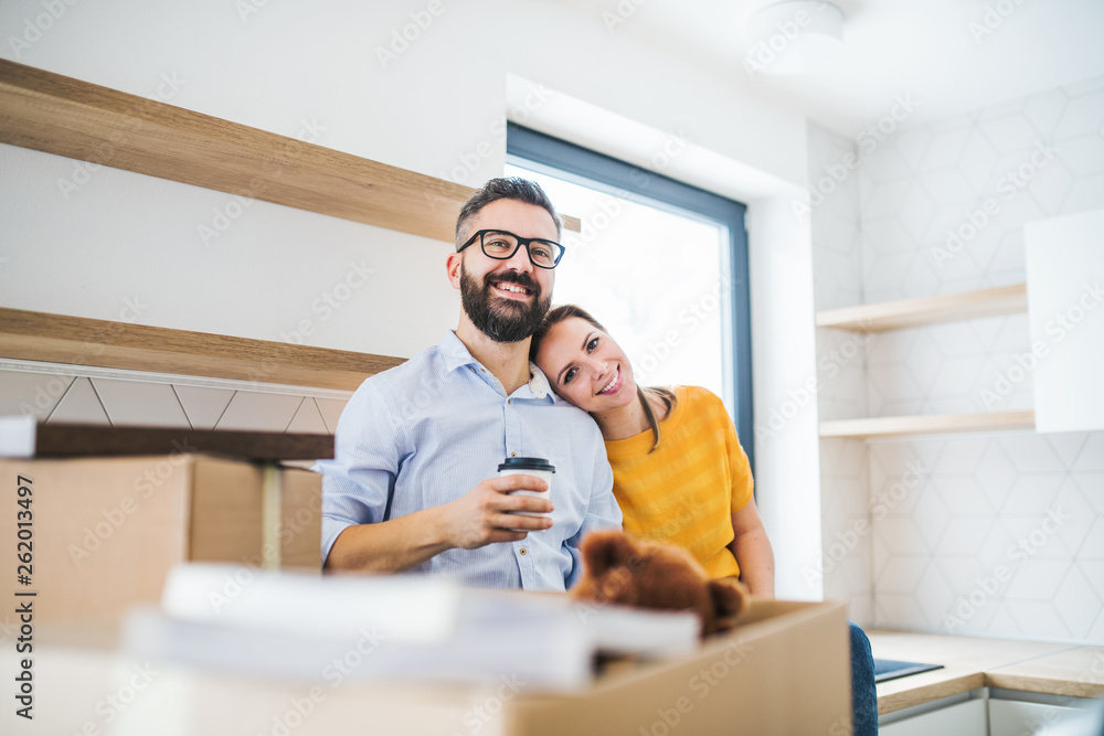 A young couple drinking coffee when moving in new home. A young couple drinking coffee when moving in new home.