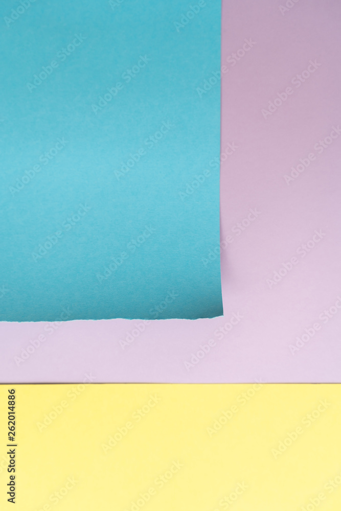 Vertical purple-blue-yellow paper background. A piece of blue paper with torn edges and yellow stripe on the background of a sheet of purple paper Vertical purple-blue-yellow paper background. A piece of blue paper with torn edges and yellow stripe on the background of a sheet of purple paper