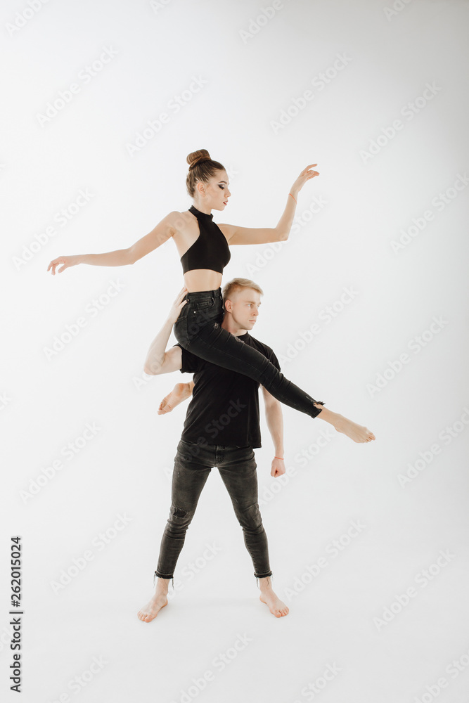 Young Athletic Couple Performing Art Dance Element. Man Stand Straight, Woman Dancer Sit on Partner Shoulder. Perfomer in Black Denim Looking at Side Isolated on White Background