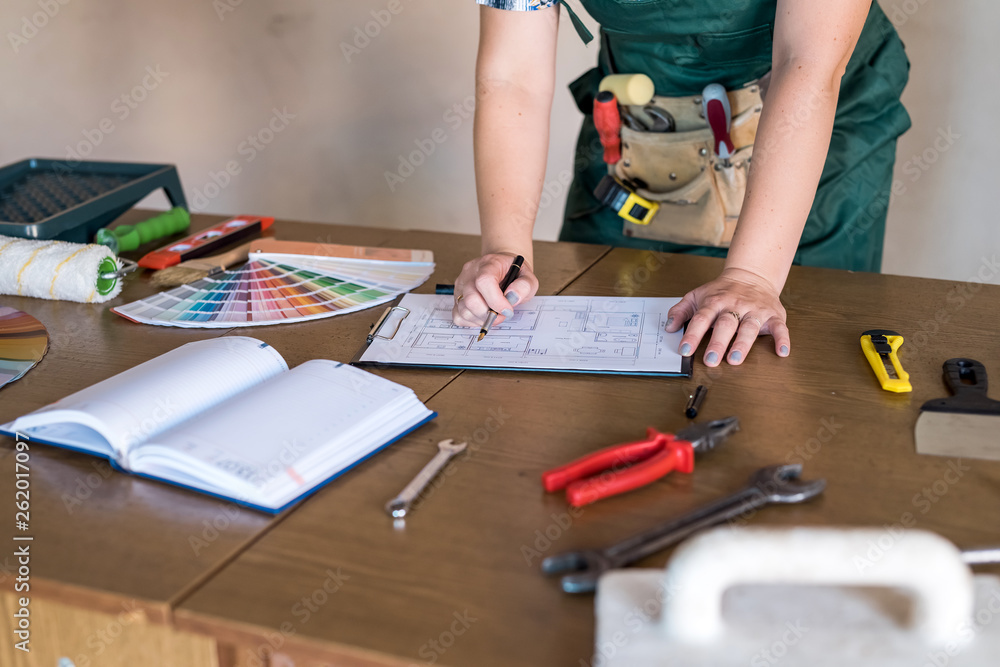 Designer's working place with house plan, colour sampler and tools Designer's working place with house plan, colour sampler and tools