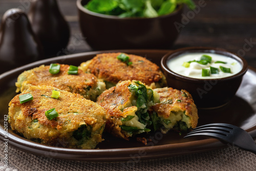 Homemade potato and spinach croquettes with yogurt dip.