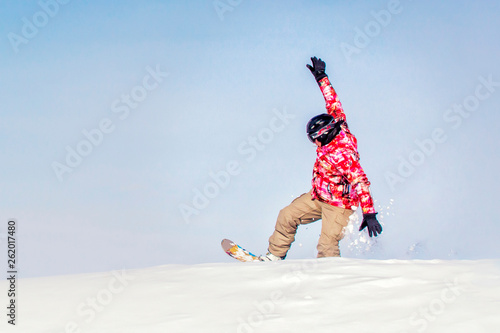 Snowboarder at jump inhigh mountains at sunny day. Copy space photo