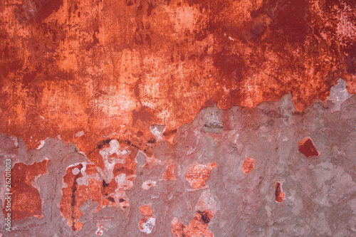 old shabby and peeling red gray concrete wall with damages and scratches. rough surface texture