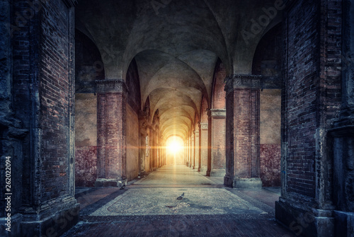 Stampa su tela Rays of divine light illuminate old arches and columns of ancient buildings