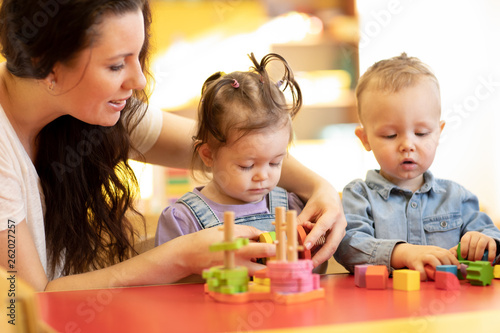 Children play with shapes and colorful wooden puzzle in a montessori classroom