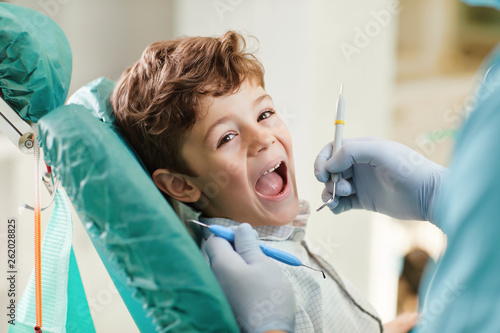 Fotografija Child smiling while sitting in the dentist's chair.