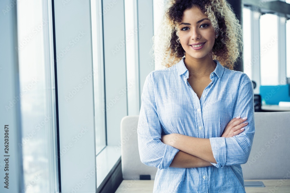 Modern young African business woman in the office with copy space. Modern young African business woman in the office with copy space.