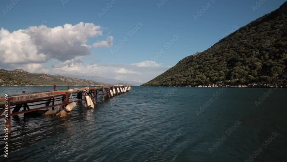 Timelapse of old wooden pier in the sea with mountains on backgorund Timelapse of old wooden pier in the sea with mountains on backgorund
