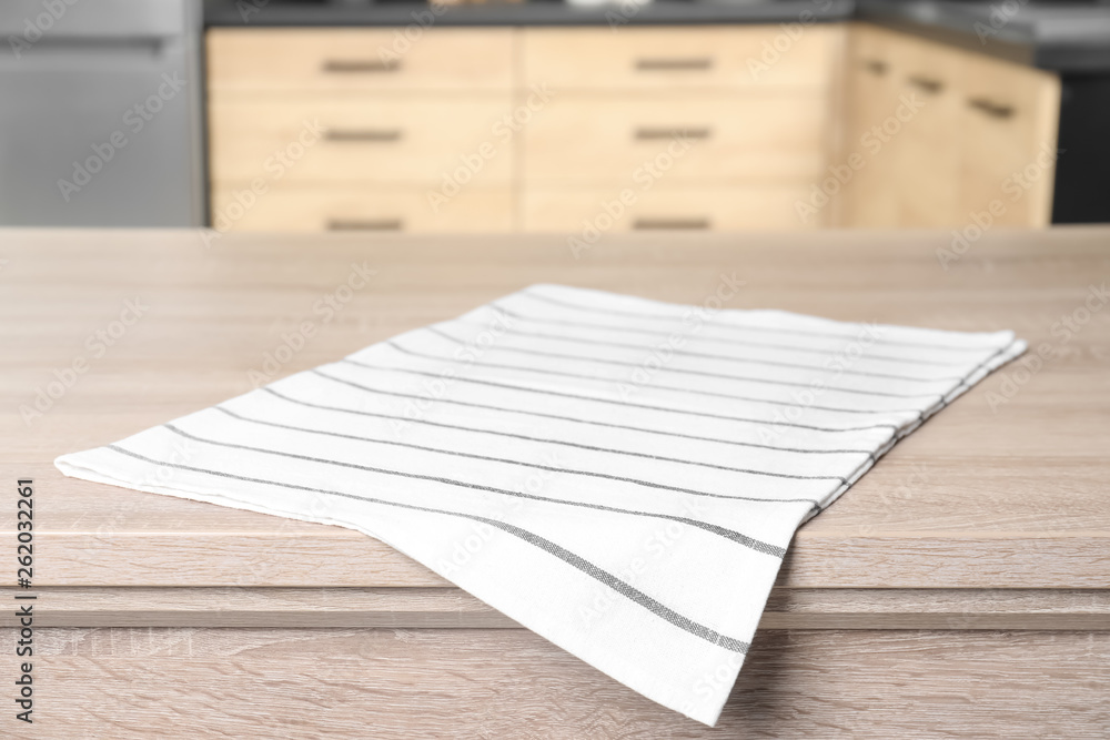 Napkin on wooden table in kitchen. Mockup for design