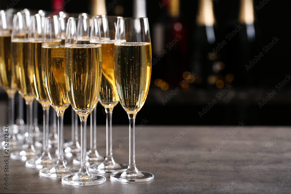 Glasses of champagne on table against blurred background. Space for text