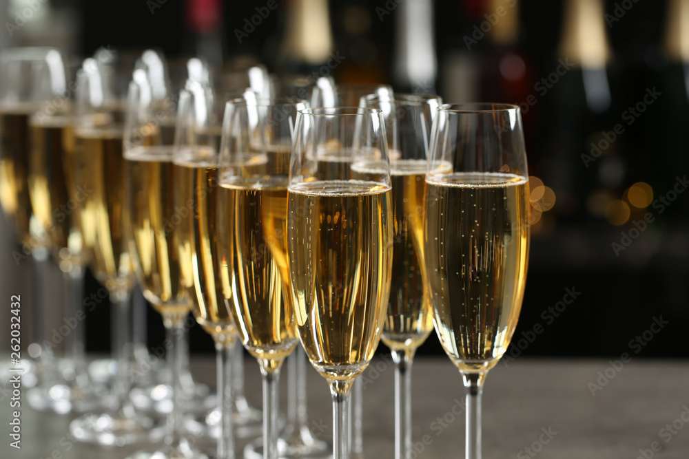 Many glasses of champagne on blurred background, closeup Many glasses of champagne on blurred background, closeup