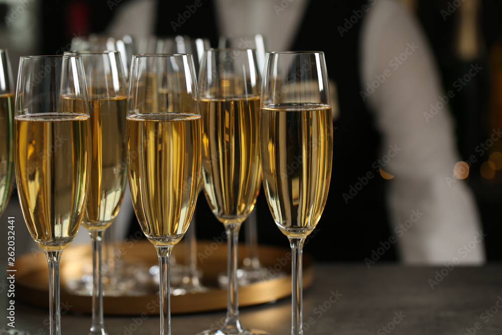 Glasses of champagne and waiter in restaurant, closeup Glasses of champagne and waiter in restaurant, closeup
