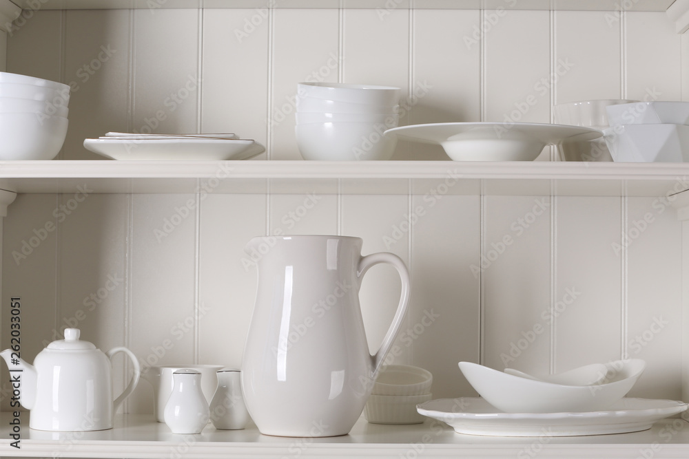 Stylish storage stand with different ceramic dishware at home Stylish storage stand with different ceramic dishware at home