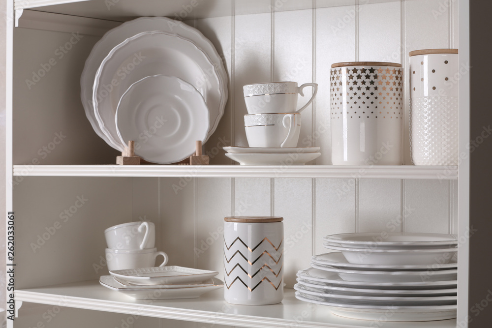 Stylish storage stand with different ceramic dishware at home Stylish storage stand with different ceramic dishware at home