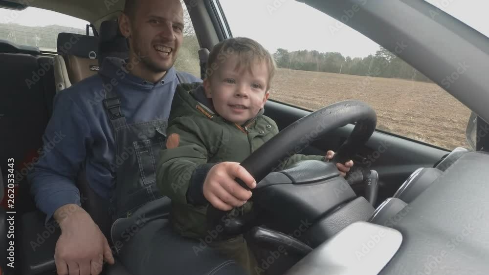 father teaches two year old son to drive car. father teaches two year old son to drive car.