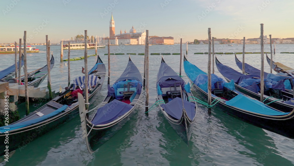 15030_A_row_of_black_gondolas_tied_on_each_poles_in_Venice_Italy.jpg